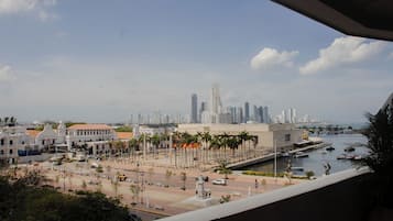 A cityscape with a prominent building, a waterfront, and a statue in the foreground.