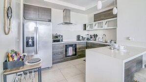 A modern kitchen with a built-in oven, microwave, and refrigerator.