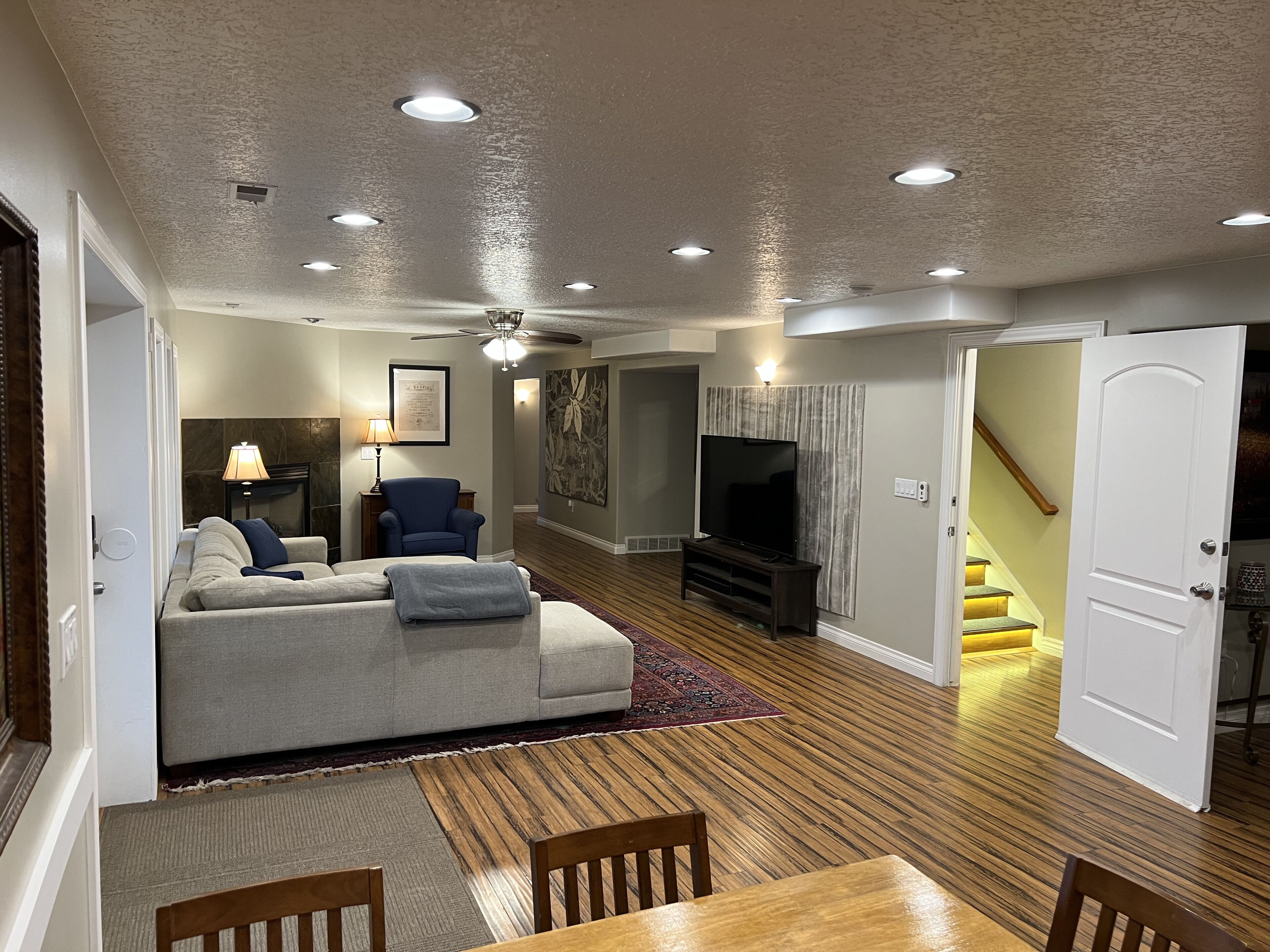 A living room with a sofa, TV, and a dining area with a table and chairs.