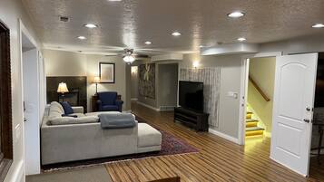A living room with a sofa, TV, and a dining area with a table and chairs.