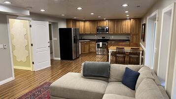 A modern kitchen with wooden cabinets, a stainless steel refrigerator, and a microwave.