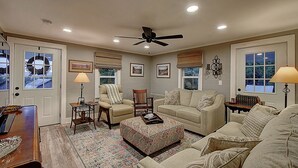 A living room with a ceiling fan, two armchairs, a sofa, a coffee table, and a patterned rug. - Charming 4-bedroom farmhouse in Shady Valley, TN with breathtaking view (Shady Valley)