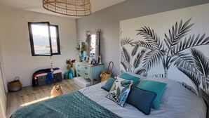 A bedroom with a bed, a large wall mural, a dresser, a mirror, and a window. - Quiet villa with forest view  (Mios)
