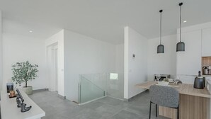 A modern kitchen with a wooden countertop, a glass partition, and pendant lighting. - Villa Teresita - Casangular by Upper (Adeje)