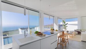 Una cucina moderna con ampie finestre, una zona pranzo e vista sull'oceano.