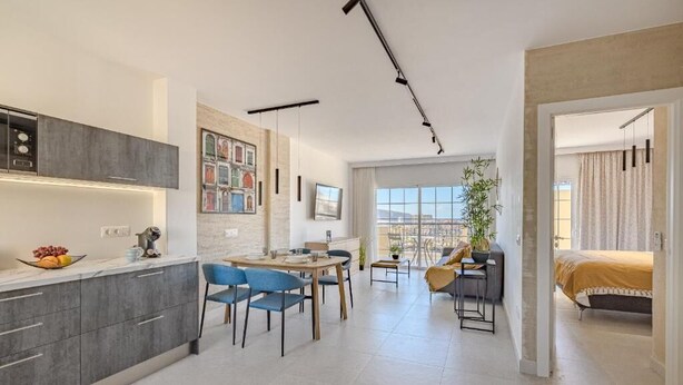 Un appartement moderne comprenant une cuisine, un coin repas et une chambre.
