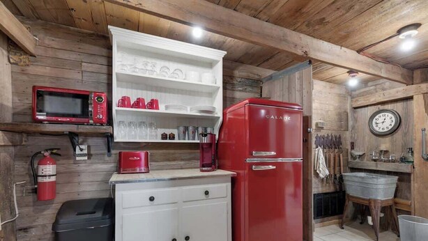 A compact kitchen with a red refrigerator, white cabinets, a microwave, and a coffee maker. - Private and Historic Rocking Ox Ranchette & Estate (Fredericksburg)