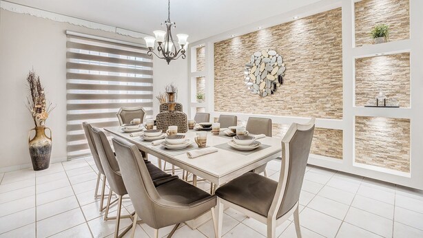 A dining room with a large table set for six, surrounded by chairs, a chandelier, and decorative wall art.