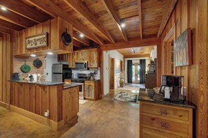 A spacious kitchen with wooden cabinets, a central island, and a dining area with a table and chairs.