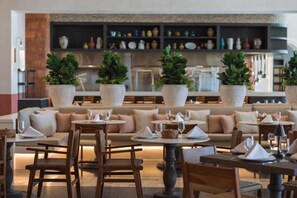Enjoy formal dining in a well-appointed space with comfortable seating and beautiful greenery.