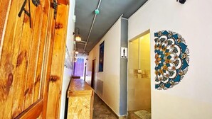 A hallway with wooden doors, a patterned wall decoration, and a tiled floor. - The Castle Star (Amman)