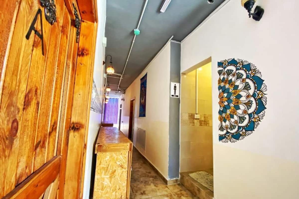 Un pasillo con puertas de madera, un adorno de pared estampado y suelo de baldosas.
