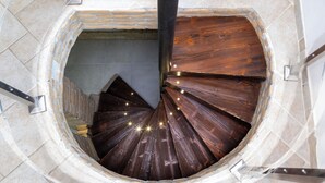 En spiraltrappe med trætrin og en murstensvæg.