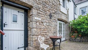 Un edificio in pietra con una porta bianca e un cartello con la scritta 'THE STABLE'.