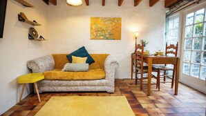 Un soggiorno accogliente con un divano a fantasia, un tavolo da pranzo in legno e un'ampia finestra.