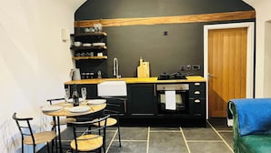 Uma cozinha compacta com área de refeições, pia e porta.
