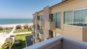 Un hotel moderno con balcón que da a una playa y al océano.