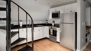A modern kitchen with white cabinets, a stainless steel refrigerator, a microwave, and a built-in oven. - MountainWaters - Mtn, River, Relax! - Hottub, Private Riverfront, Firepit. (Maurertown)