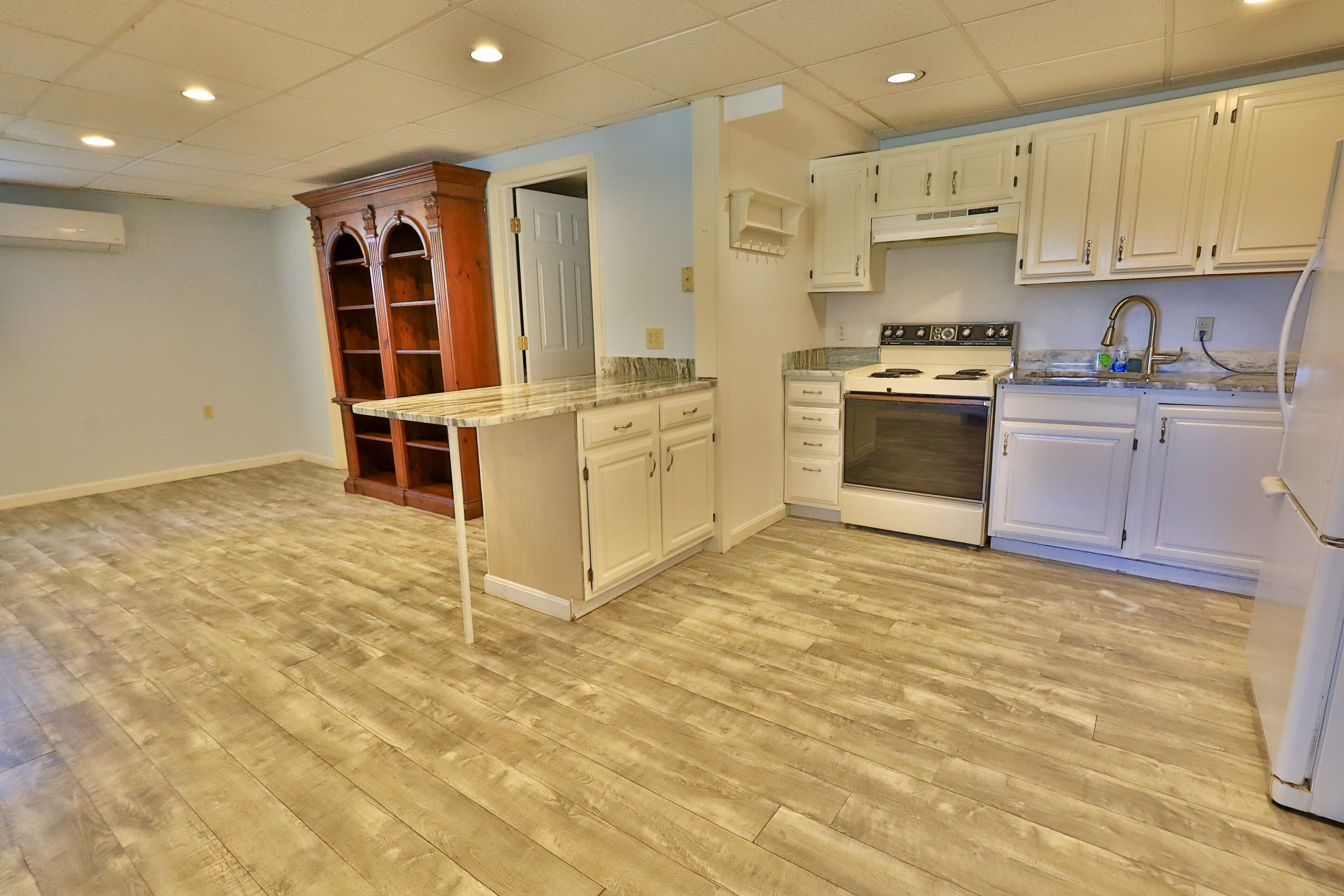 A kitchen with white cabinets, a built-in oven, and a refrigerator.