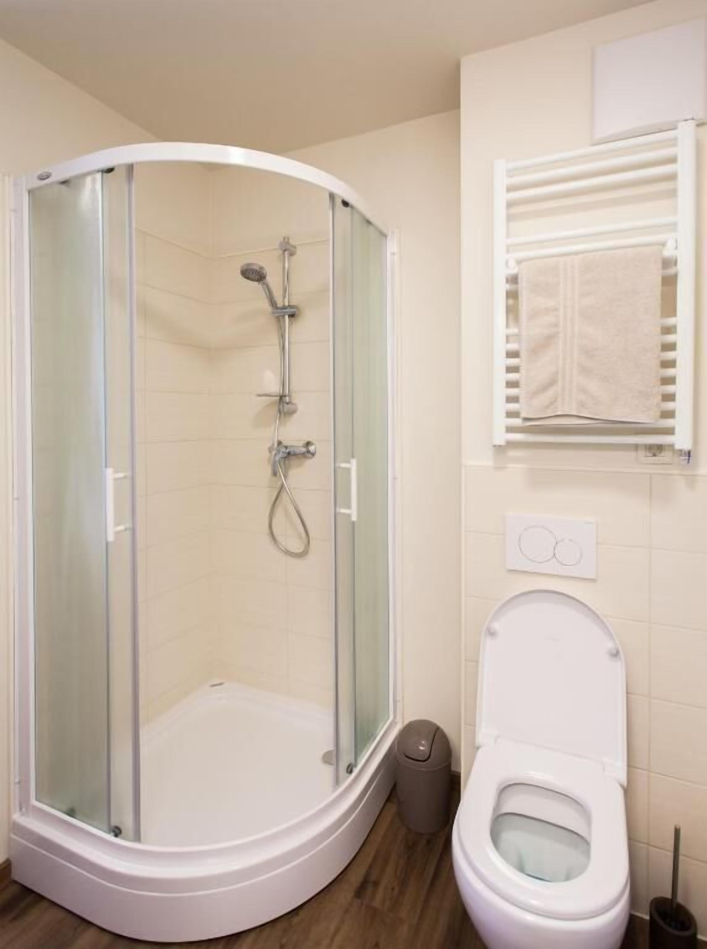 Ein Badezimmer mit Duschkabine, Toilette und Handtuchhalter.