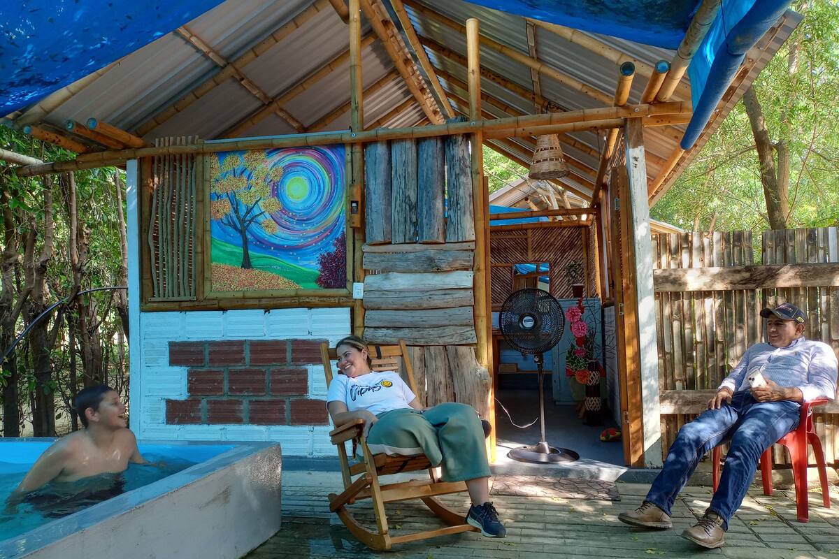 Een houten constructie met een muurschildering, een zwembad en een overdekte zithoek.