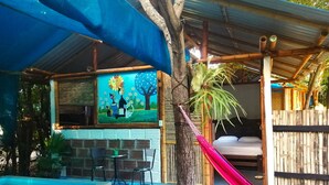 Zona de piscina con una hamaca, un cuadro y un pequeño espacio de estar al aire libre.