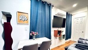 A modern living room with a dining area, a TV, and a cozy seating area. - New! Suite nearby Rittenhouse Square (Philadelphia)