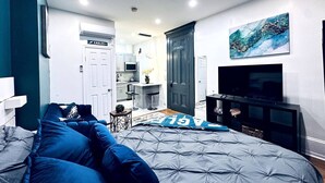 A bedroom with a bed, a TV, a wardrobe, and a kitchenette in the background. - New! Suite by Rittenhouse Square! (Philadelphia)