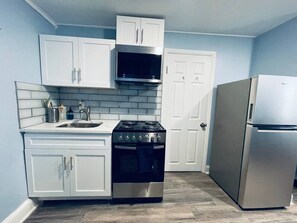 A kitchen with white cabinets, a stainless steel stove, a microwave, and a refrigerator. - Rittenhouse Square close by Kimmel Center Suite (Philadelphia)