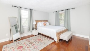 A bedroom with a wooden bed, a nightstand, a mirror, and a bench. - Whispering WillowBnB – Cozy Central Stay Near IUP in Indiana, PA (Indiana)