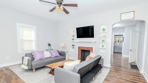 A modern living room with a grey sofa, a coffee table, and a fireplace. A flat-screen TV is mounted above the fireplace. - Whispering WillowBnB – Cozy Central Stay Near IUP in Indiana, PA (Indiana)