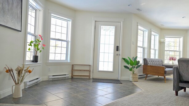 A spacious living room with large windows, a fireplace, and a comfortable seating area. - Charming 2-bedroom guest suite in the prime location of Fredericton (Fredericton)
