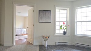 A room with a bed, a potted plant, a framed artwork, and a window with a view. - Charming 2-bedroom guest suite in the prime location of Fredericton (Fredericton)