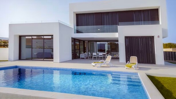 Uma casa moderna de dois andares com piscina, área de estar externa e varanda coberta.