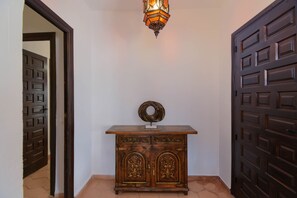 A hallway with a wooden cabinet, a decorative light fixture, and two doors. - Beautiful villa near the sea and golf course (Benissa)