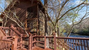 A wooden cabin with a deck and a river view. - Talking Waters - Fishing Camp (Blue Ridge)