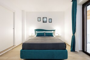 A bedroom with a bed, a window with curtains, and framed pictures on the wall. - Maison Lorelle (Sorrento)