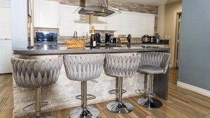 A modern kitchen with a central island, bar stools, and stainless steel appliances. - Beautiful and cozy family house with pool and barbecue. (Las Vegas)