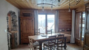 Un interior de madera con una mesa de comedor, sillas y una pared de piedra.