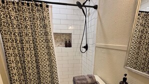 A bathroom with a shower curtain, a toilet, a sink with a towel, and a soap dispenser.