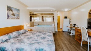 A bedroom with a bed, a desk, a chair, a sink, and a bathtub. - Western Budget Plus Cold Lake (Cold Lake)