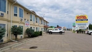 A motel with a sign advertising 2 queens with full kitchen for $89.00 per night. - Western Budget Plus Cold Lake (Cold Lake)