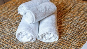 Two white towels stacked on a woven textured surface.