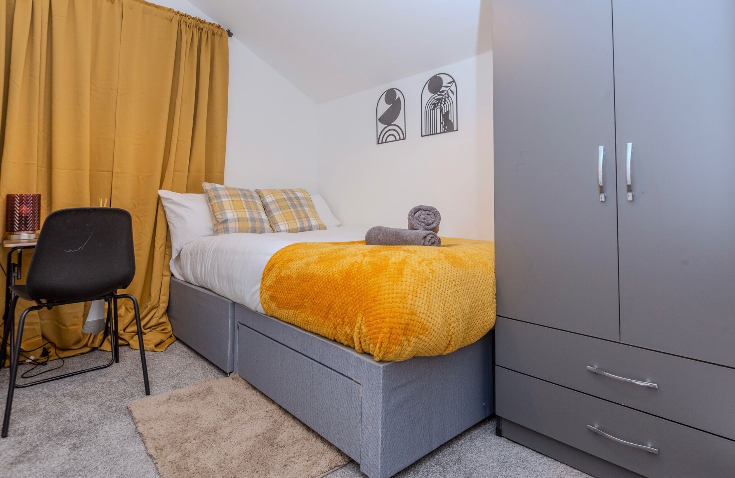 Un dormitorio con cama, escritorio, silla y armario.