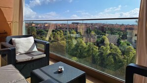 Un balcon offrant une vue sur le paysage urbain et la verdure.