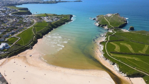 An aerial view of a coastal area with a sandy beach, a clear blue sea, and a residential area with houses and green fields. - Newquay Seaside Lodge Retreat With Hot Tub (Newquay)