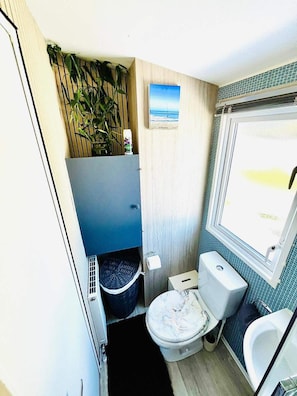 Un baño pequeño con inodoro, bidé y una ventana.