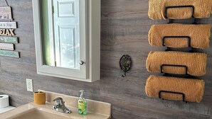 Une salle de bain équipée d’un lavabo, d’un miroir et d’un porte-serviettes.