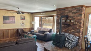 Un salon chaleureux avec une cheminée, des meubles en bois et une grande fenêtre.