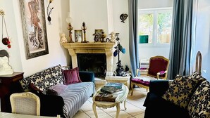 Un salon chaleureux avec une cheminée, un canapé, un fauteuil et une table.